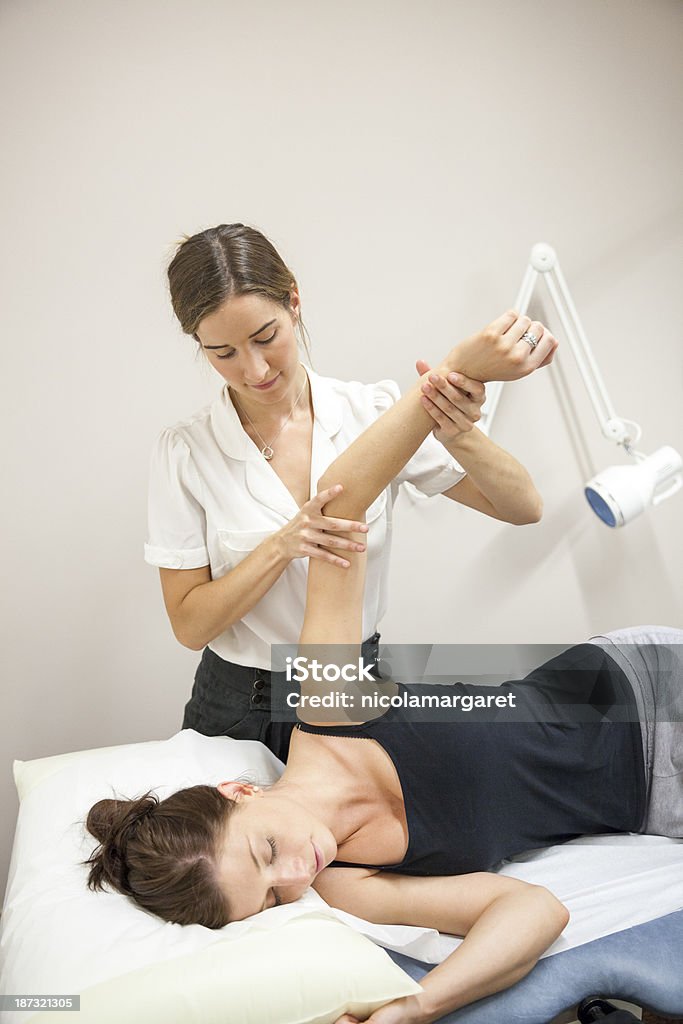 Physical Therapist Series: shoulder/arm mobility Osteopath or Physiotherapist assessing her patient's arm and shoulder movement 25-29 Years Stock Photo