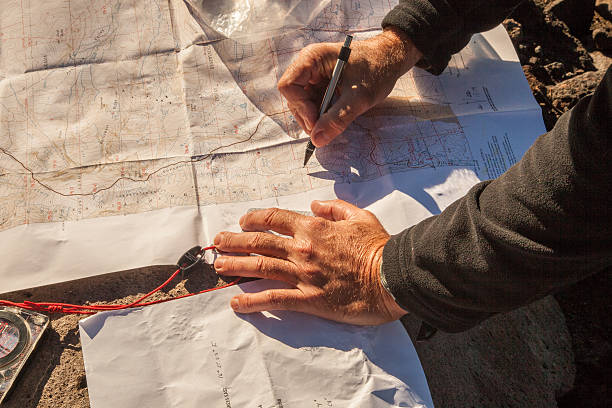 Hiker drawing on topography map with pen