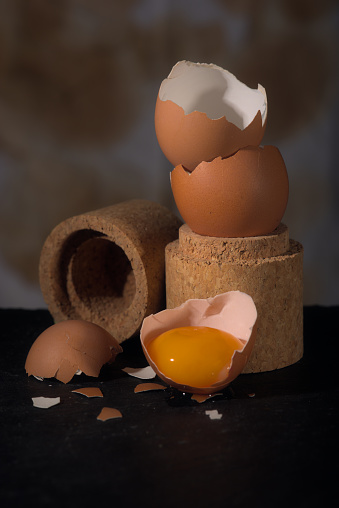 Raw egg yolk and stacked eggshells, studio composition