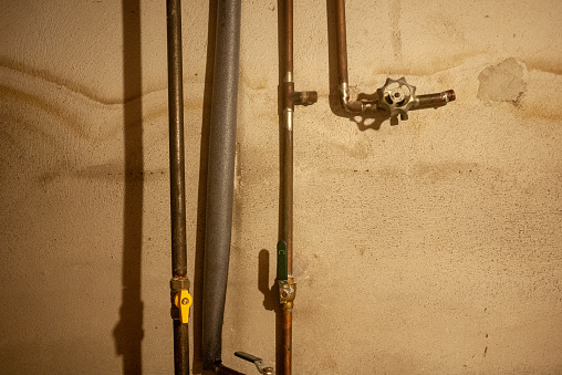 Set of old copper water pipes in the basement of a Canadian home.