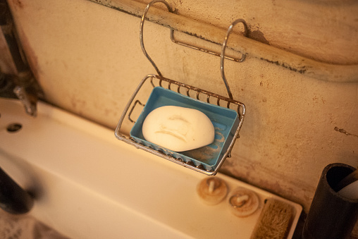 Vintage wire soap tray with an old bar of white soap. Hanging over an old basement laundry tub in a Canadian home.