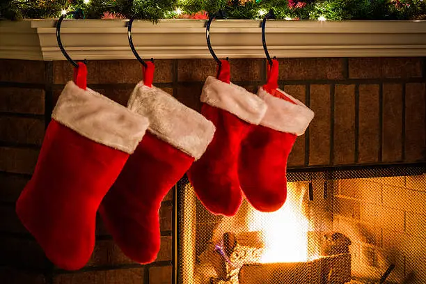 Holiday season fireplace with red stockings, decorated Christmas tree and mantlepiece
