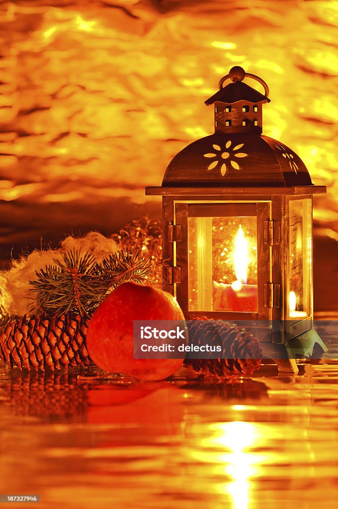 Xmas lantern Christmas decoration with lantern, candles, angel hair, fir branch, pine cones and apple. In a warm candlelight atmosphere. Apple - Fruit Stock Photo