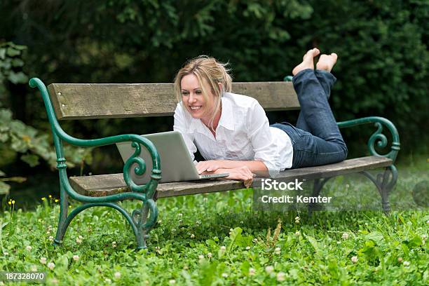 笑顔の若い女性が公園のベンチラップ - 1人のストックフォトや画像を多数ご用意 - 1人, 20代, 30代