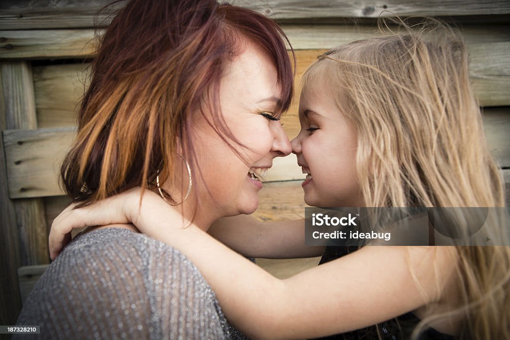 Mother and Little Daughter Cuddling, in Outdoor Setting Color image of a happy mom cuddling with her little girl, in outdoor setting. 30-34 Years Stock Photo