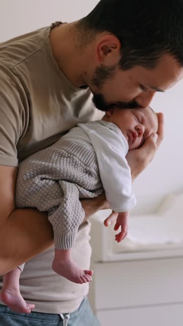 SLO MO Young Father Kissing Sleeping Newborn Baby on his Hand at Home