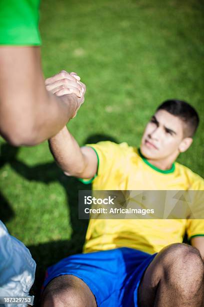 Soccer Players Helping Each Other Stock Photo - Download Image Now - Holding Hands, Loyalty, Picking Up