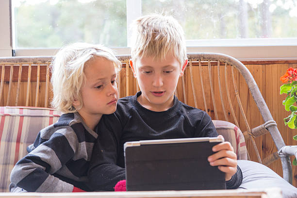 istock Little brothers concentrating on the screen where something interesting happens. 187329827