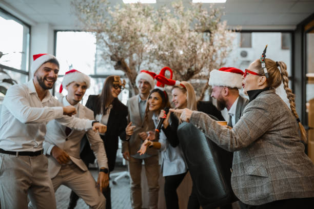 Colleagues Singing And Dancing During Christmas Party In Office