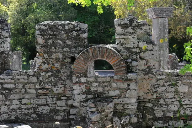 Remains of a round-arch window on the outer wall of the VI century AD dated circular structure of the baptistery with columns around a central font, Butrint archaeological site. Vlore county-Albania.