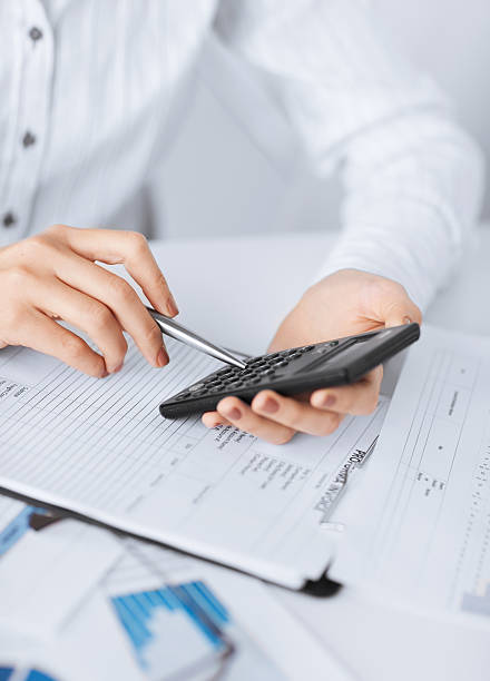 istock woman hand with calculator and papers 187332442