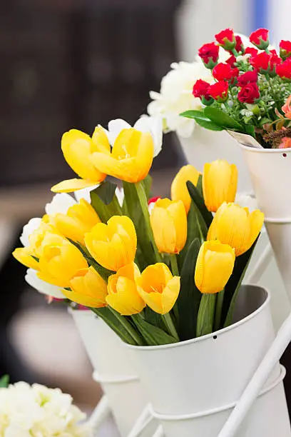 artificial yellow tulips in white pot