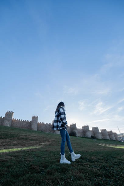 istock Woman explores medieval Avila's historic walls. 1873344422