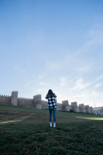 istock Woman in checkered jacket, touring Avila. 1873344423