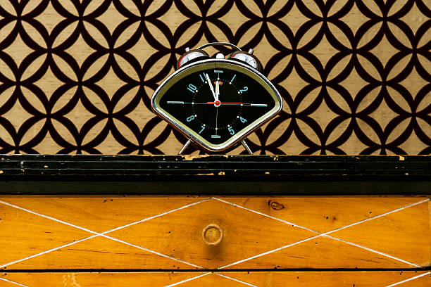 Retro alarm clock on night table stock photo