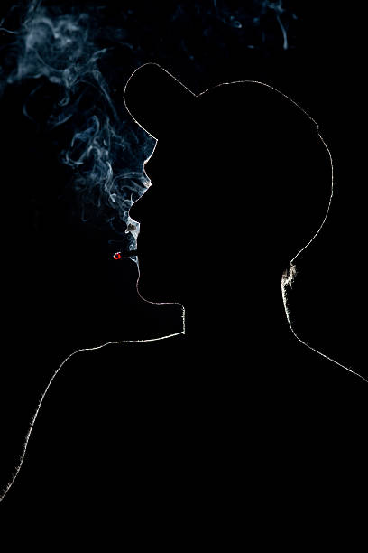 Young Adult Smoking a cigarette in silhouette stock photo