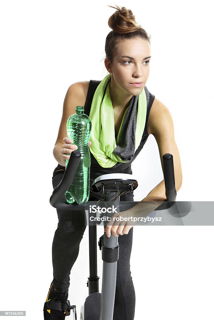 girl  riding a bike girl in a black sweat suit riding a bike and drinking water Exercising Stock Photo