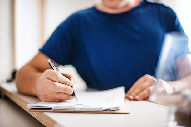 istock Patient filling in is health declaration at the reception 187336491