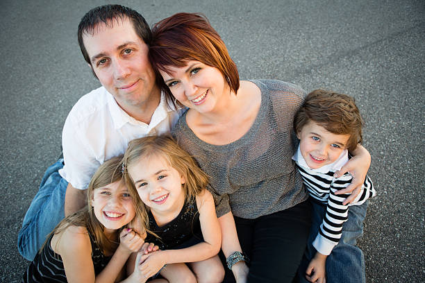 istock Family of Five Sitting Kneeling on Asphalt 187337657