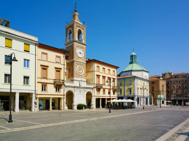 istock Piazza Tre Martiri Three Martyrs square with traditional buildings with clock and bell tower in old historical touristic city centre Rimini with blue sky background, Emilia-Romagna, Italy 1873380312