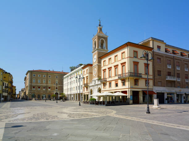 istock Piazza Tre Martiri Three Martyrs square with traditional buildings with clock and bell tower in old historical touristic city centre Rimini with blue sky background, Emilia-Romagna, Italy 1873380315