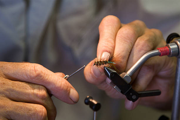 istock Fisherman hands tying flies for fishing 187338121