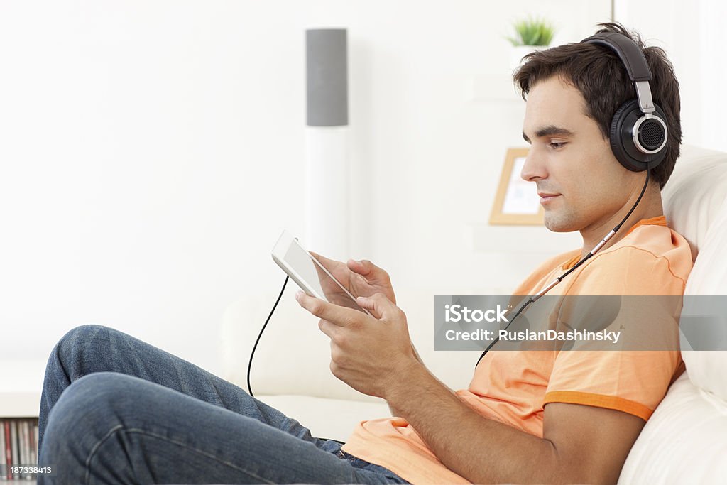 Jeune homme écoute de la musique avec tablette numérique. - Photo de Adolescent libre de droits