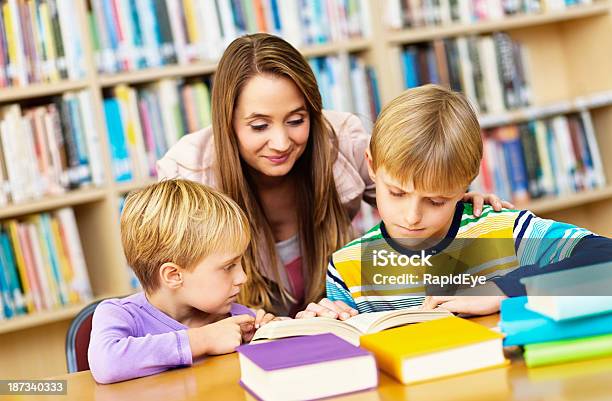 Photo libre de droit de Heureuse Famille De Passer Du Temps Ensemble Dans La Bibliothèque banque d'images et plus d'images libres de droit de 10-11 ans