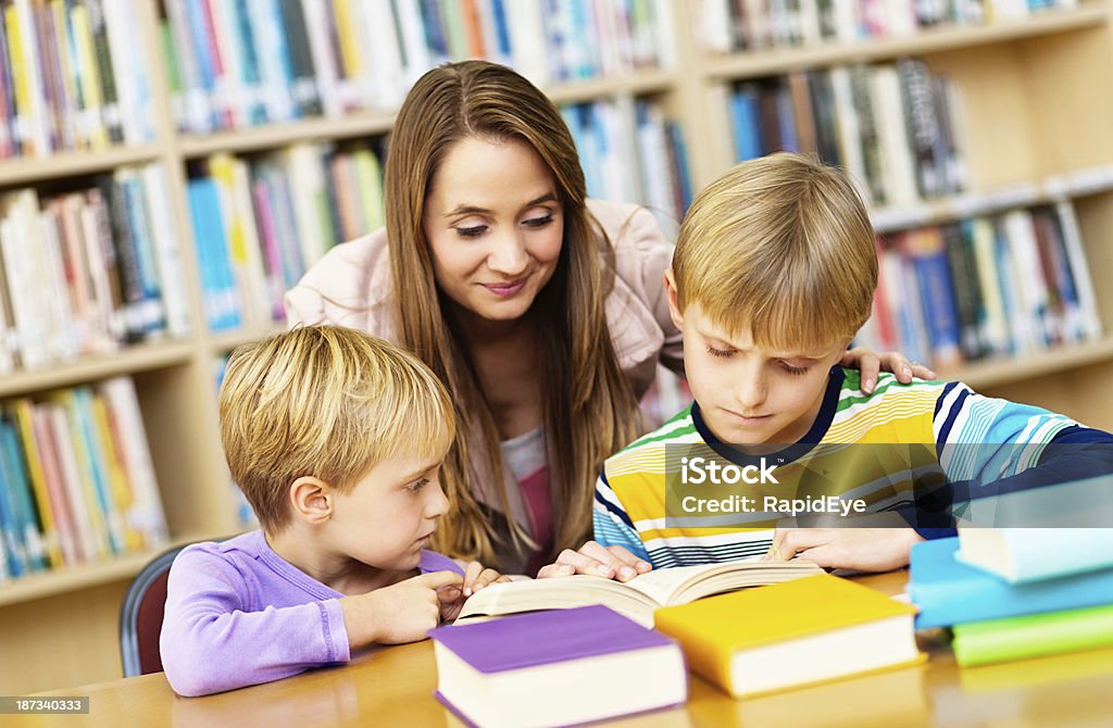 Famiglia felice di trascorrere del tempo insieme in biblioteca - Foto stock royalty-free di 10-11 anni