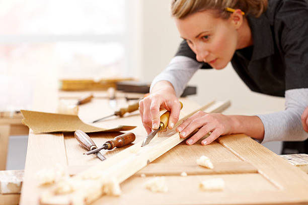 istock Female carpenter carving wood 187343689