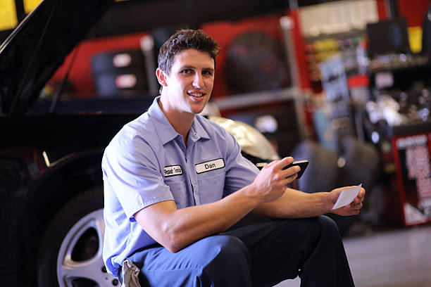istock Auto Mechanic Depositing Check with Mobile Phone 187343736