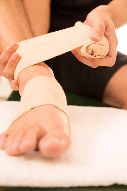 istock Medical:  Male athlete with ankle injury. Locker room. 187344367