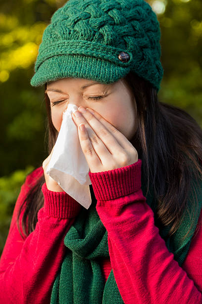 istock Healthcare:  Woman with flu or allergies sneezes while outside. 187344369