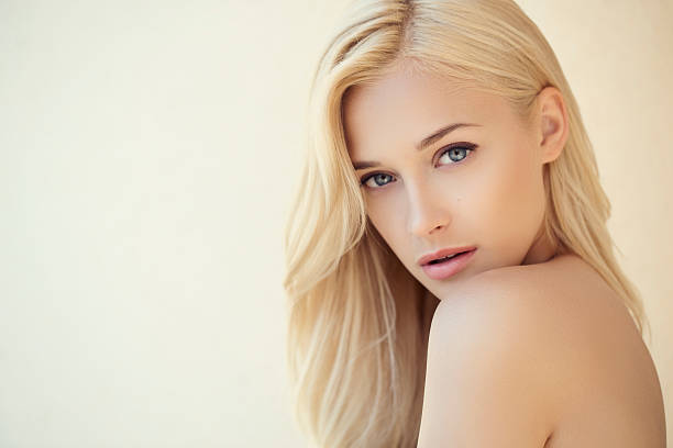 Beautiful woman Outdoor shot of young beautiful woman on light background. Professional make up and hair style. blond hair stock pictures, royalty-free photos & images