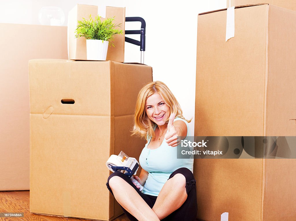 Job finished! Satisfied young woman showing thumbs up, happy with the packing finished. For more images from this shoot, click on the IMAGE BELOW: 30-39 Years Stock Photo