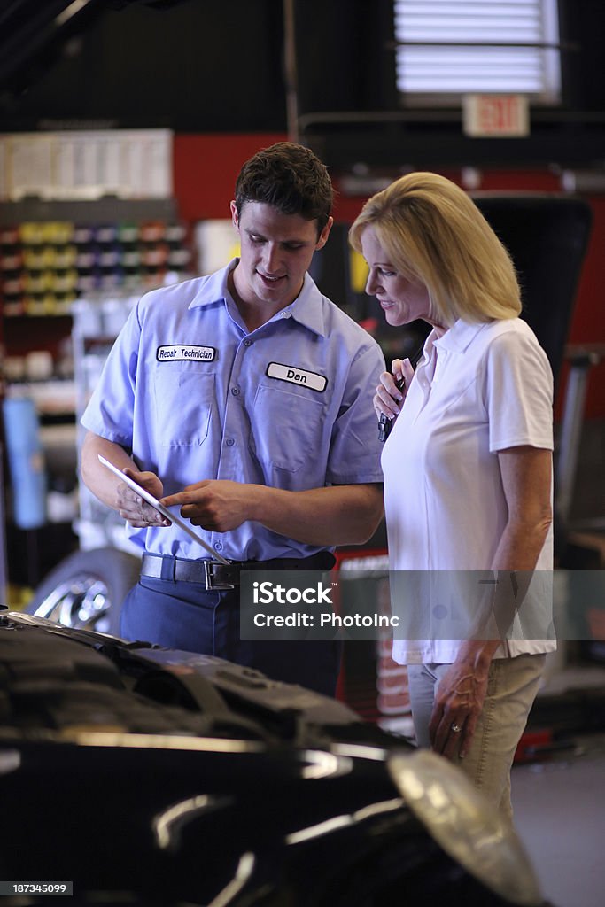 Auto mechanic pointing on his tablet to a customer Auto Mechanic using digital tablet to show Customer completed workhttp://i449.photobucket.com/albums/qq220/iphotoinc/MobileBankingLightbox_zps4f4602a2.jpg Car Stock Photo