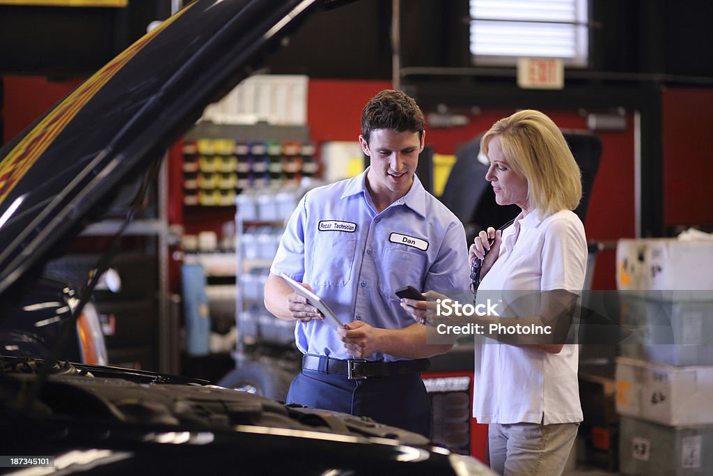 Auto Mechanic using digital tablet to show Customer completed work Auto Mechanic using digital tablet to show Customer completed workhttp://i449.photobucket.com/albums/qq220/iphotoinc/MobileBankingLightbox_zps4f4602a2.jpg Customer Stock Photo