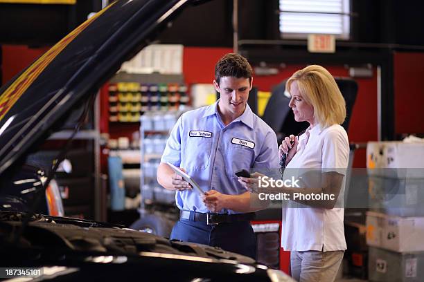 Auto Mechanic Using Digital Tablet To Show Customer Completed Work Stock Photo - Download Image Now