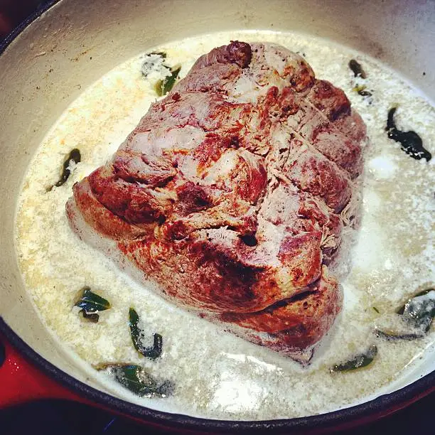 A pork loin being braised in milk (recipe for the Italian dish maiale al latte) with sage.  Taken with an iPhone and processed in Instagram.