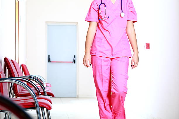 Nurse standing with folded hands on the blurred background.