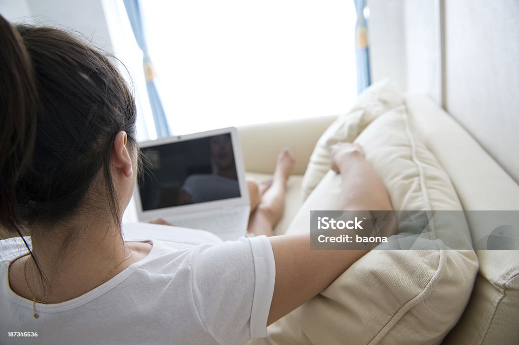 Usando o laptop no sofá - Foto de stock de Adulto royalty-free