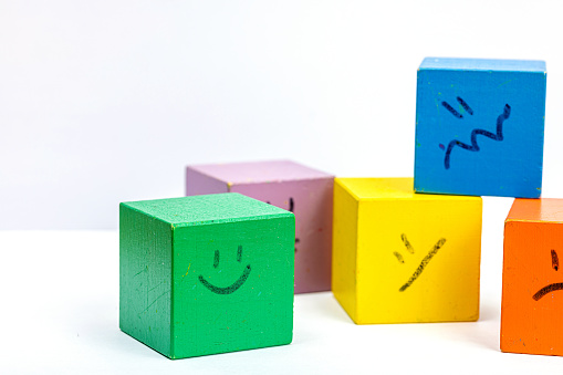 World mental health day. wooden cubes with different emotions. Feedback rating, customer review, experience, satisfaction survey or assessment concept, flat lay, selective focus
