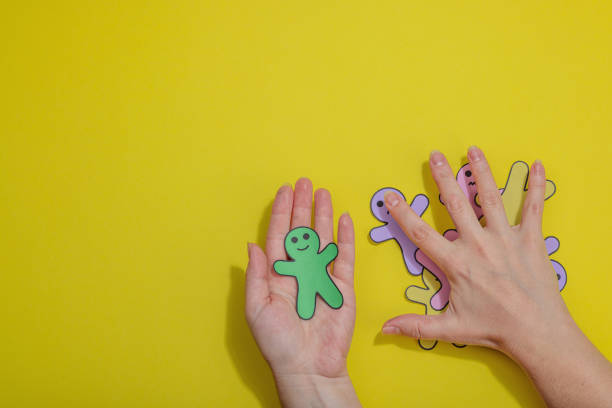 istock World mental health day. Female hands holding paper men figures with different emotions 1873473286