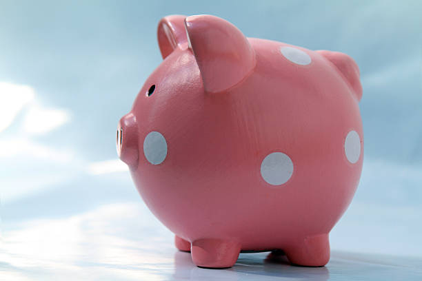 istock pink piggy bank profile against sky 187347746