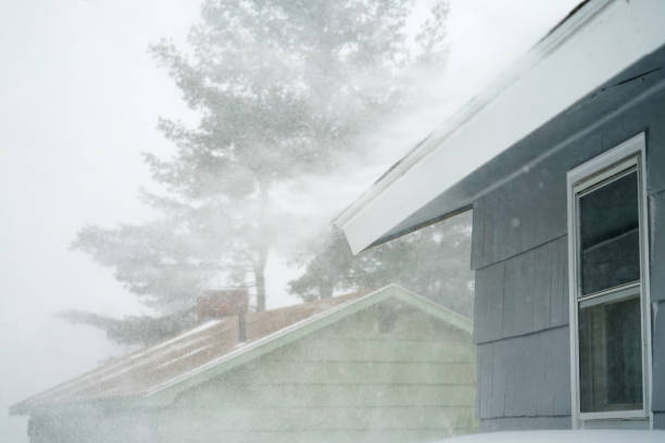 istock strong wind blowing snow off the roof in blizzard 1873494678