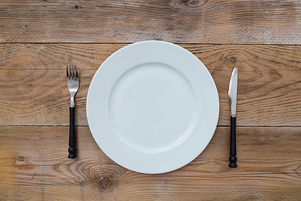 istock White plate and cutlery on wood 187349706