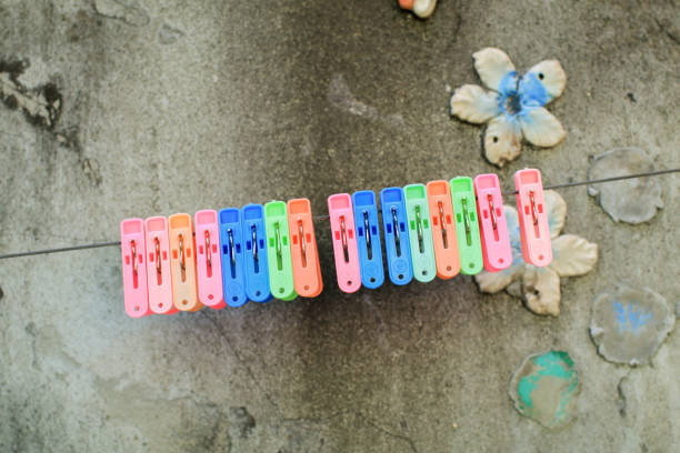 istock Multi colored clothespins on the rope for drying clothes, Housework and household concept. Clamping clothes that are dried in the sun so they don't come loose in the wind. 1873515599