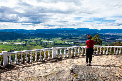 Young woman at a viewpoint over the beautiful Sopo valley at the department of Cundinamarca in Colombia