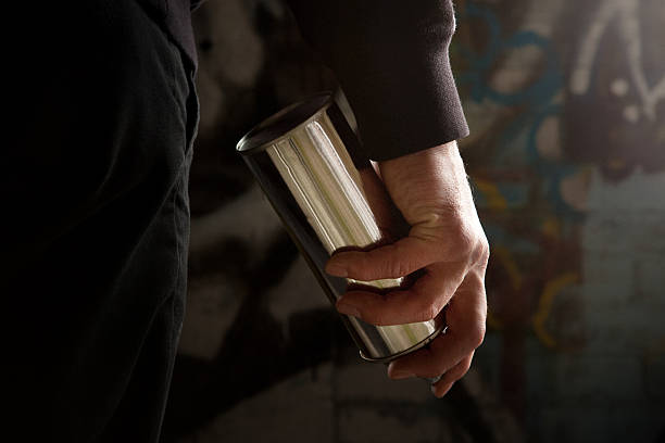 Young man standing with a silver spray can in his hand stock photo
