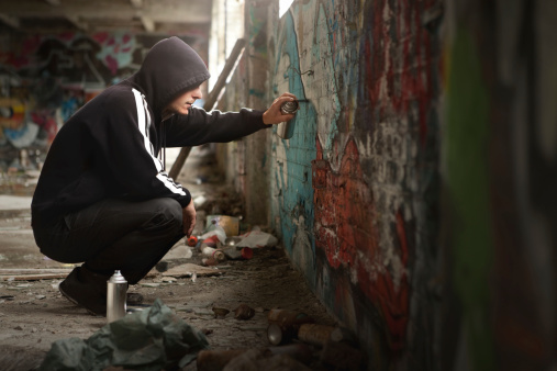 Ilegal y pulverización de pintura joven en pared de Graffiti. photo